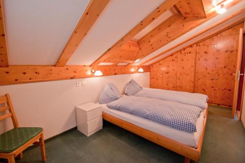 a bedroom with a bed and a chair at Dent Blanche in Zermatt