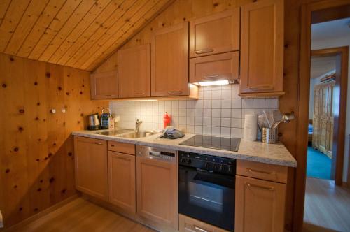 a kitchen with wooden cabinets and a sink and a stove at Dent Blanche in Zermatt