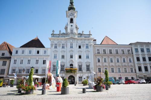 un gran edificio blanco con una torre de reloj en la parte superior en Steyr City Apartment mit 2 Schlafzimmer, en Steyr