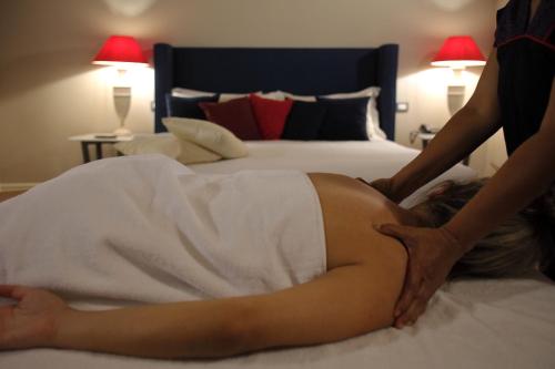 a woman in a white dress laying on a bed at Residenza Palazzo Fortuna - Boutique Hotel in Civita Castellana