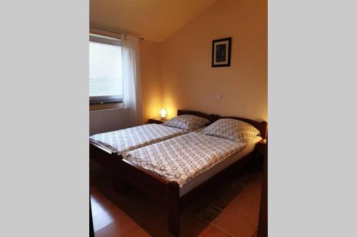 un letto in una camera da letto con finestra e un letto sidx sidx. di Apartman Stela a Poreč (Parenzo)