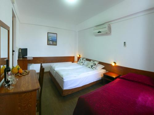 a hotel room with a bed and a desk and a bed sidx sidx at Villa Milev in Kranevo
