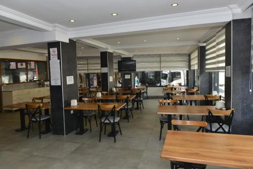 a dining room with wooden tables and chairs at Bilgic Hotel in Kırklareli