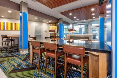 a lobby with a large bar with stools at Holiday Inn Express & Suites - Grand Rapids Airport - South by IHG in Grand Rapids