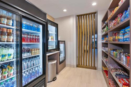 a grocery store aisle with a refrigerator filled with drinks at Holiday Inn Express & Suites - Grand Rapids Airport - South by IHG in Grand Rapids