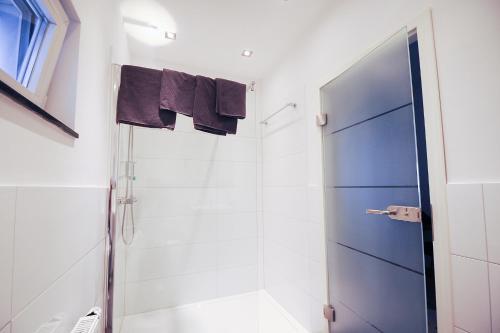 a bathroom with a shower and a blue door at Appartements Papillon in Gevelsberg