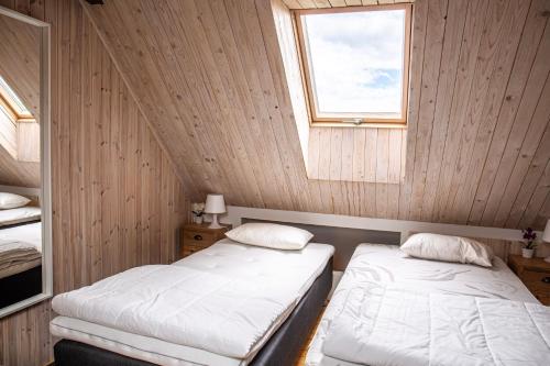 two beds in a room with a window at Ravlunda Byaväg 12 in Kivik