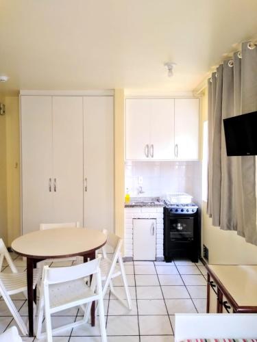 a kitchen with a table and a kitchen with a stove at Pousada Vó Regina in Florianópolis