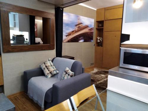 un salon avec un canapé et une télévision dans l'établissement Paris Interiors Rentals - Le Marais LOUVRE - NOTRE DAME, à Paris