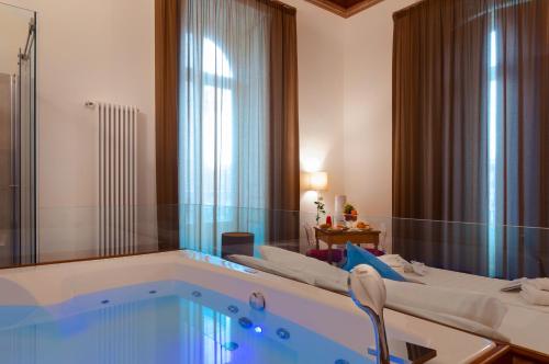 a bathroom with a large tub with a large window at Naca Suite in Catania