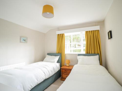 two beds in a room with a window at Fell Foot in Holmrook
