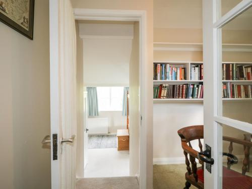 an open door leading into a room with bookshelves at Fell Foot in Holmrook