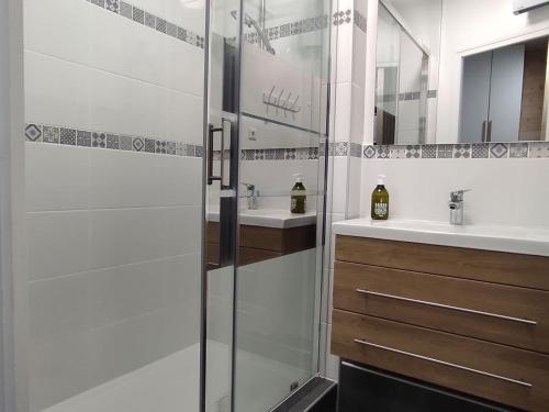uma casa de banho com uma cabina de duche em vidro e um lavatório. em Studio avec terrasse et parking 200m plage et commerces em La Couarde-sur-Mer