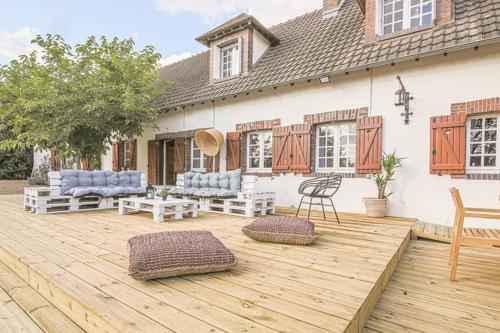 a wooden deck with chairs and a house at Kasa Des Bois in Saint-Arnoult-des-Bois