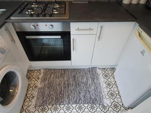 a kitchen with a stove and a washing machine at Next to Aintree Golf Course in Aintree