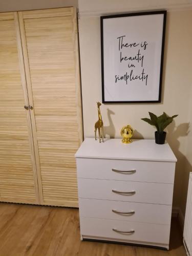 a white dresser in a room with a closet at Next to Aintree Golf Course in Aintree