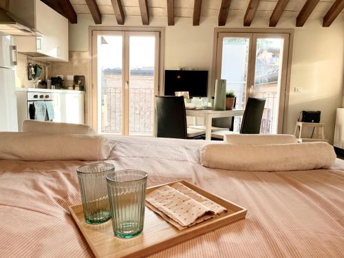 a table with two glasses and a tray on a bed at Niki O. Apartments in Parma