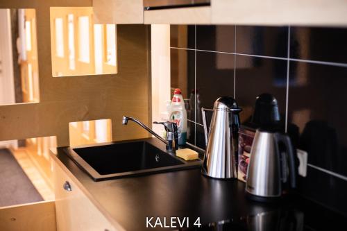 a kitchen with a black counter top with a sink at City Center Turu str apartments, parking, Tartu Home in Tartu