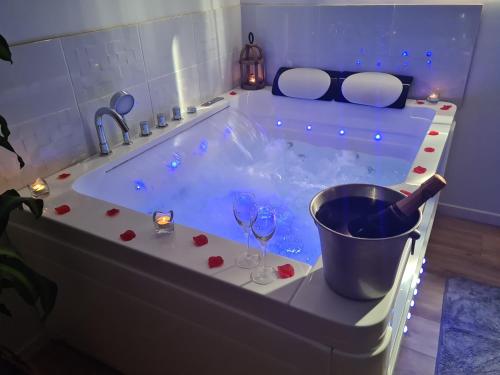 - une baignoire avec une bouteille de vin et des verres à vin dans l'établissement L escapade amoureuse, à Bournezeau