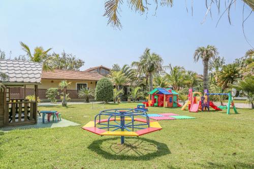 um parque infantil com equipamento colorido num quintal em Praia do Estaleiro Guest House no Balneário Camboriú
