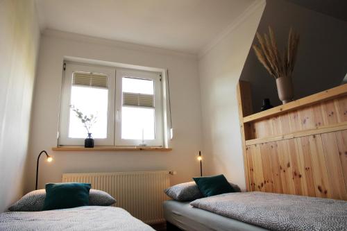 a bedroom with two beds and a window at Ferienwohnung Siedlungsnest in Anklam