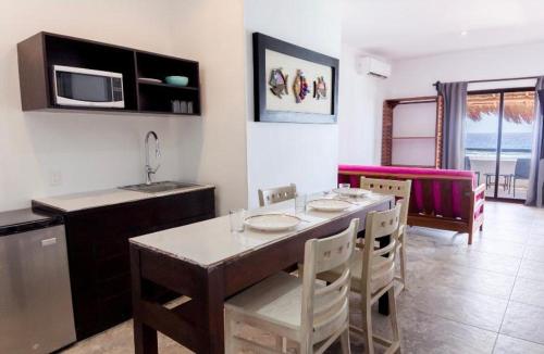 a kitchen and dining room with a table and chairs at Hotel Blue Reef frente al mar in Mahahual
