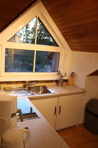 a kitchen with a sink and a window at Stadtblick in Soltau