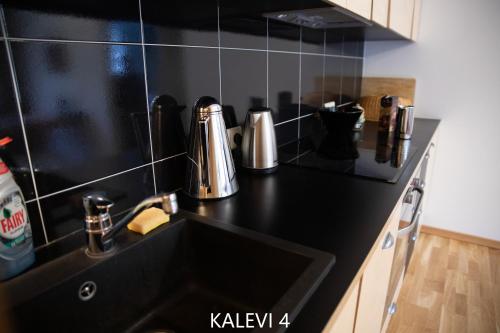a kitchen with a black counter top with a sink at City Center Turu str apartments, parking, Tartu Home in Tartu
