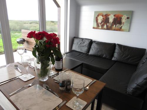 a living room with a table with red roses on it at Islandcorr Farm Luxury Glamping Lodges and Self Catering Cottage, Giant's Causeway in Bushmills