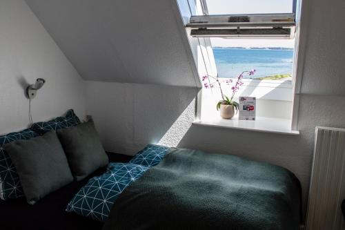 Habitación pequeña con cama y ventana en Samsø Perlen, en Sælvig
