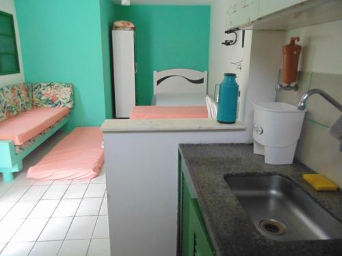een kleine keuken met een wastafel en een toilet bij Sunny Chalés na prainha do jacaré muito próximo in Caraguatatuba