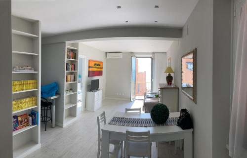 a room with a table and chairs and a dining room at Rosso Tramonto luxury-white- LADISPOLI, Lungomare Regina Elena 58 in Ladispoli