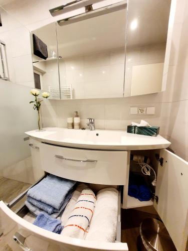 a bathroom with a sink and a mirror and towels at Ferienwohnung Baumann in Neupotz