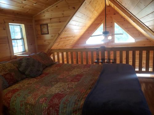 a bedroom with a bed in a wooden cabin at The Genoa - An Amish Built Deluxe Cabin in Genoa