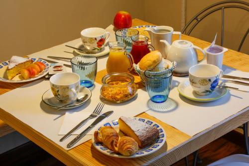 a table with plates of pastries and cups of orange juice at B&B Ai Tre Cavalli in Cherasco