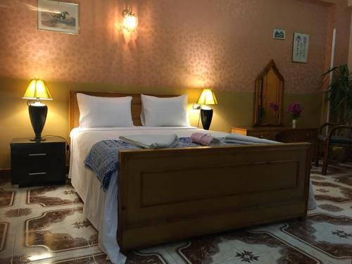 una camera da letto con un grande letto con due lampade sopra di Al Gezera Apartments a Luxor