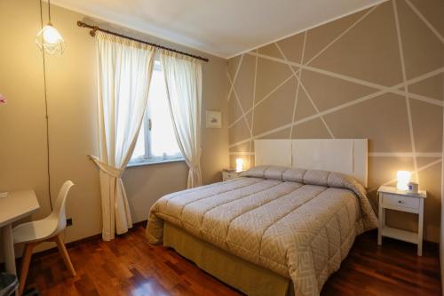 a bedroom with a bed and a desk and a window at B&B Ai Tre Cavalli in Cherasco
