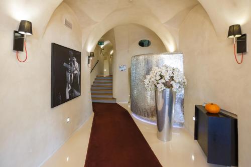 a hallway with a vase of flowers and a staircase at Hotel Aplaus in Litomyšl