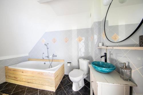 a bathroom with a tub and a toilet and a sink at Blossom Hill Apartments in Łęcze
