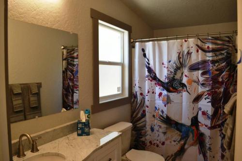 a bathroom with a shower curtain with a bird pattern at In The Oaks in Three Rivers