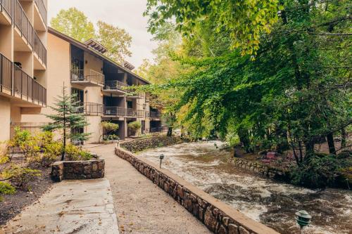 a river next to some buildings and a street at Brookside Lodge in Gatlinburg