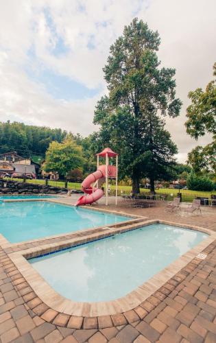 a pool with a water slide in a park at Brookside Lodge - Gatlinburg - On the River in Gatlinburg