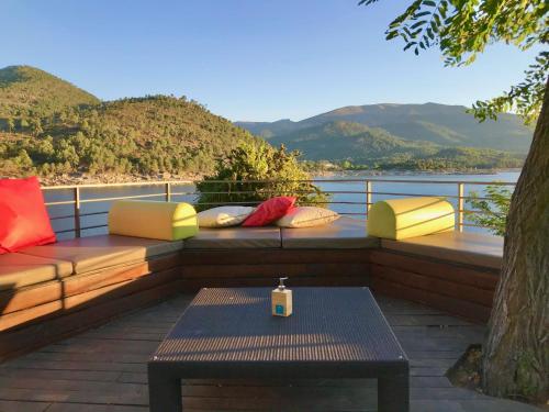 a patio with a bench and a table with a view at Posada del Agua in El Barraco