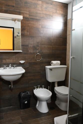 a bathroom with a sink and a toilet and a mirror at Rancho Grande Hostel in El Chalten