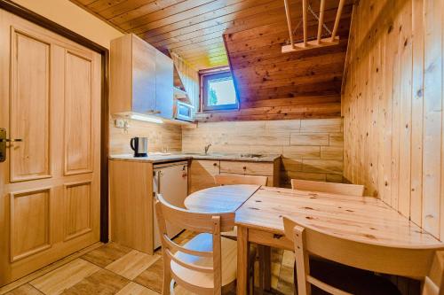 a wooden kitchen with a wooden table and chairs at Apartmány U Žaloudků in Dolní Morava
