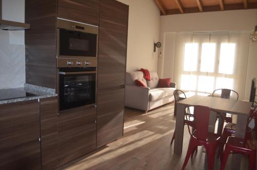 a kitchen with a stove and a living room at La Quintana del Castillo in Soto del Barco