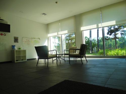 a room with a table and chairs and windows at HI Melgaco - Pousada de Juventude in Melgaço