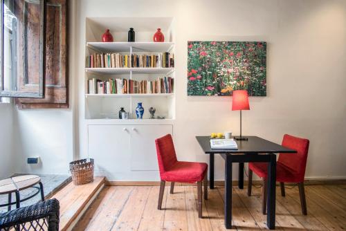 Cette chambre comprend une table, des chaises et une étagère à livres. dans l'établissement Monte della Farina Loft, à Rome