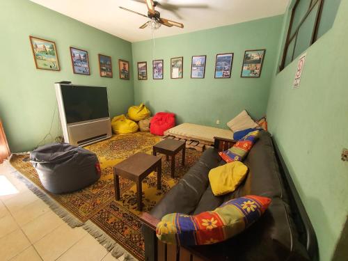 a living room with a couch and a flat screen tv at Hierba De Conejo Hostel in Oaxaca City