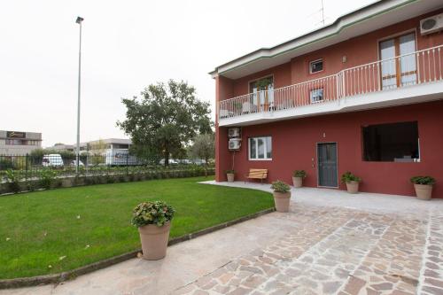 un bâtiment rouge avec une cour et une pelouse dans l'établissement Relax nel Verde, à Segrate